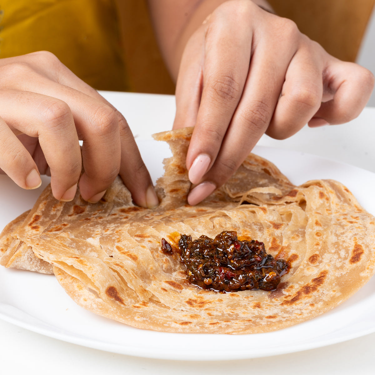 Pickle spread on a torn piece of paratha